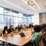 Microsoft 365 Copilot Guide Boost Productivity with AI A diverse group of professionals engaged in a meeting around a conference table with laptops in a modern office setting.