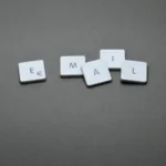 Expand Your Brand Master Email Marketing for Business Success Scrabble tiles arranged on a grey background spelling out the word 'EMAIL'.