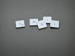 Scrabble tiles arranged on a grey background spelling out the word 'EMAIL'.