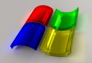 Three-dimensional rendering of semi-transparent red, green, and yellow RGB (Red, Green, Blue) color model capsules overlapping, with a subtle reflection on a gray surface.