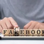 Man flipping scrabble pieces to spell fakebook.