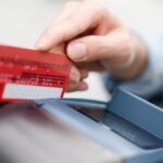 A person swiping a credit card in a terminal.